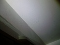 grande chambre: mur et plafond coulures de peinture et traces d'enduit mal taloché  (en lumière rasante)